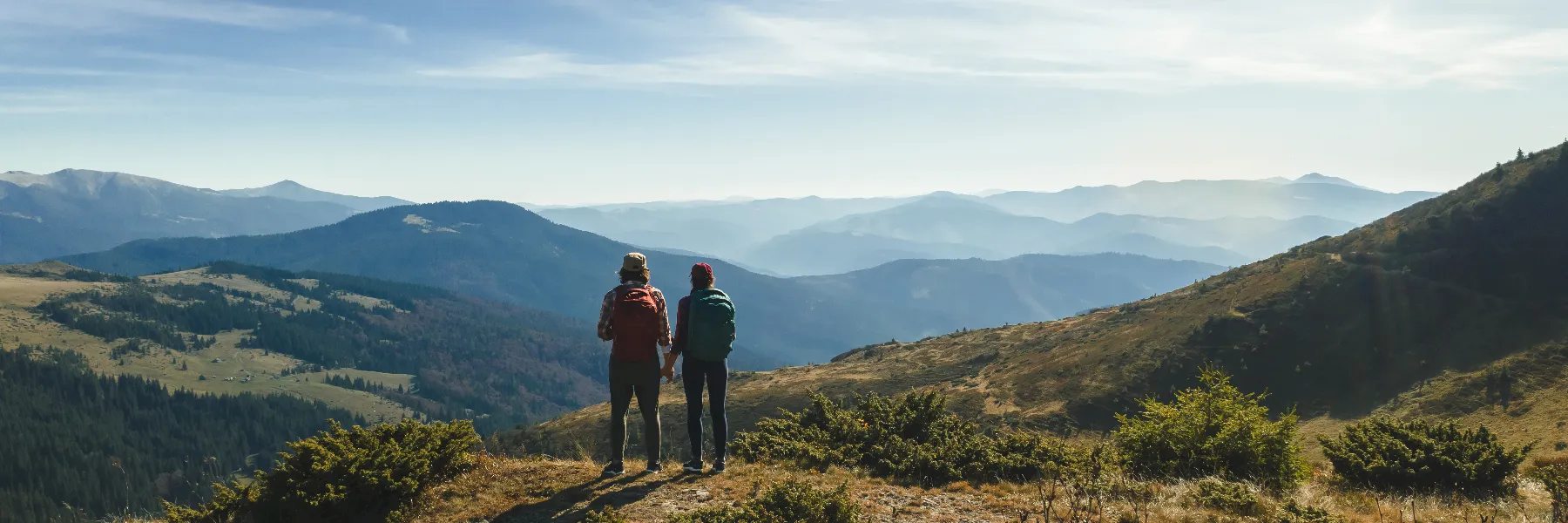 Couple embracing with a mountain landscape behind them