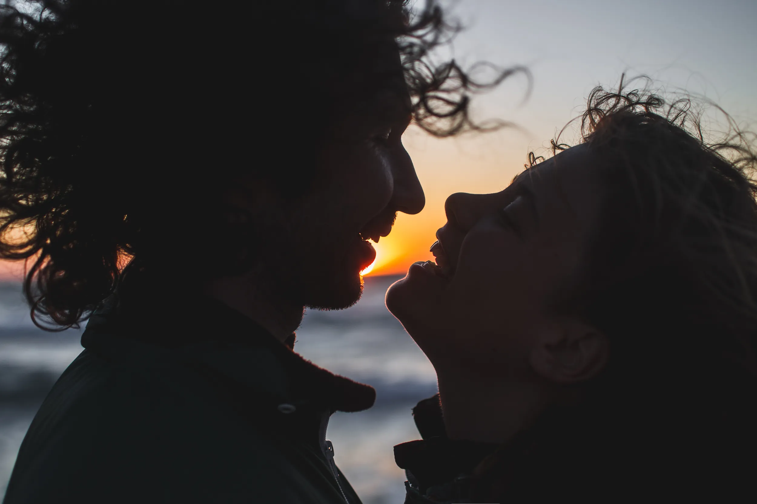 Silhouettes of a couple embracing at sunset